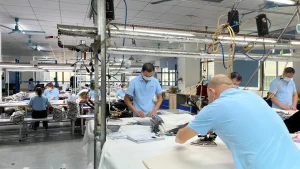 Workers inspecting custom sweater panels during knitwear sample and production review