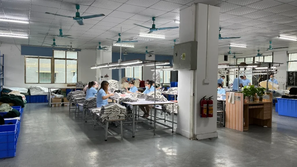 Knitwear factory workers organizing custom sweater production and yarn selection workflow