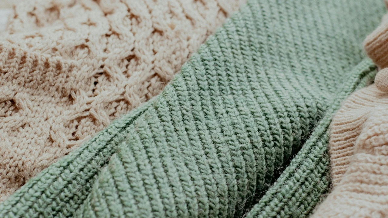 Close-up of cable knit sweater textures showing different yarn structures and stitch details