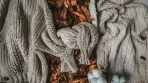 Cable knit zip up sweater styling concept with textured knitwear, scarf, and autumn leaves