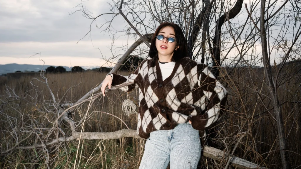 Cardigan Sweater with brown and cream argyle pattern styled outdoors.