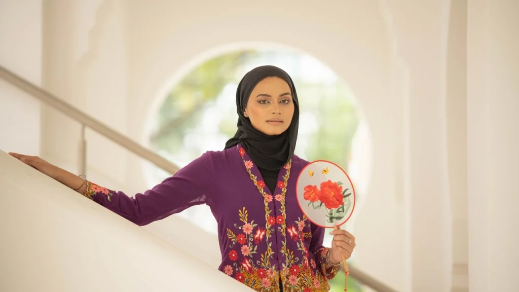Woman wearing a purple embroidered cardigan-style knitwear piece with floral details