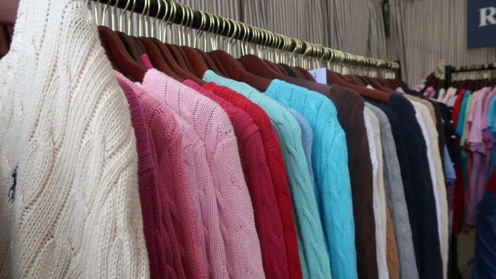 Custom Knit Sweaters displayed on hangers in multiple colors for retail-ready knitwear collections.