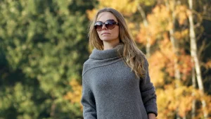 Woman wearing a grey knit maxi dress with a soft cowl neckline in an autumn outdoor setting
