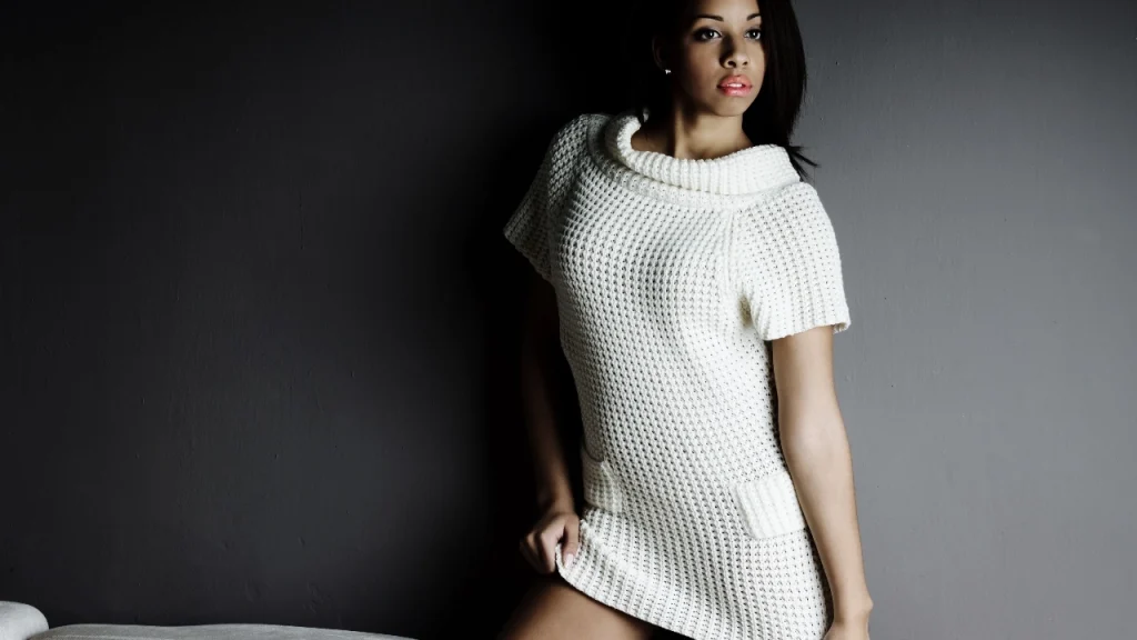 Woman wearing a white textured knit sweater dress with short sleeves and a relaxed collar.