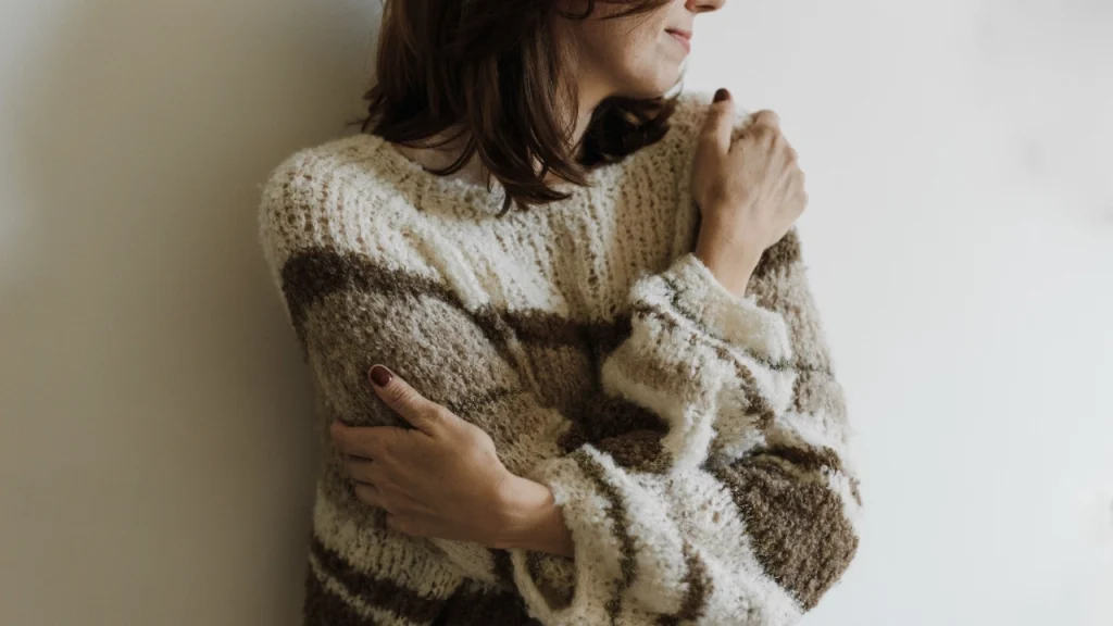 Woman wearing a textured striped sweater suitable for knitted sweater manufacturer collection inspiration