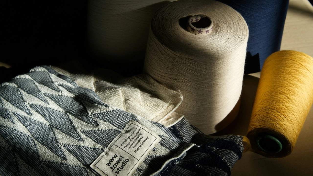 Yarn cones and knitted fabric swatch prepared for knitwear factory development