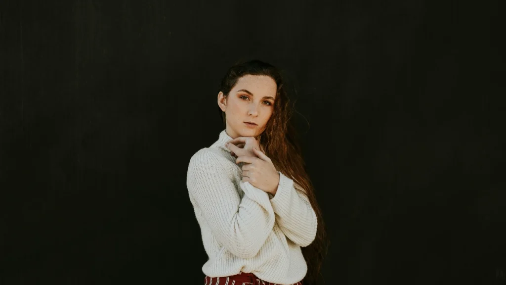 Knitwear Manufacturer cream sweater styled on a model against a dark studio background.