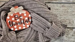 Knitwear Manufacturer folded ribbed sweater displayed with a seasonal thank-you sign.