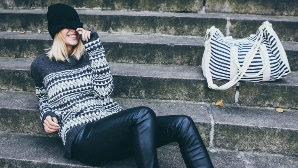 Knitwear Manufacturer patterned sweater styled on outdoor stone steps.