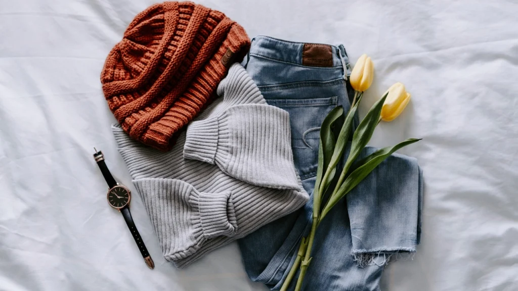 Grey knitted sweater styled with jeans and accessories for knitwear manufacturer collection planning