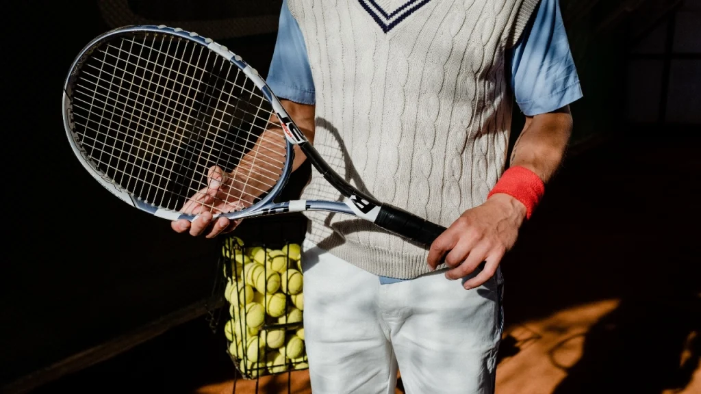 Mens sleeveless jumper in a cream cable knit design styled for a tennis-inspired outfit.