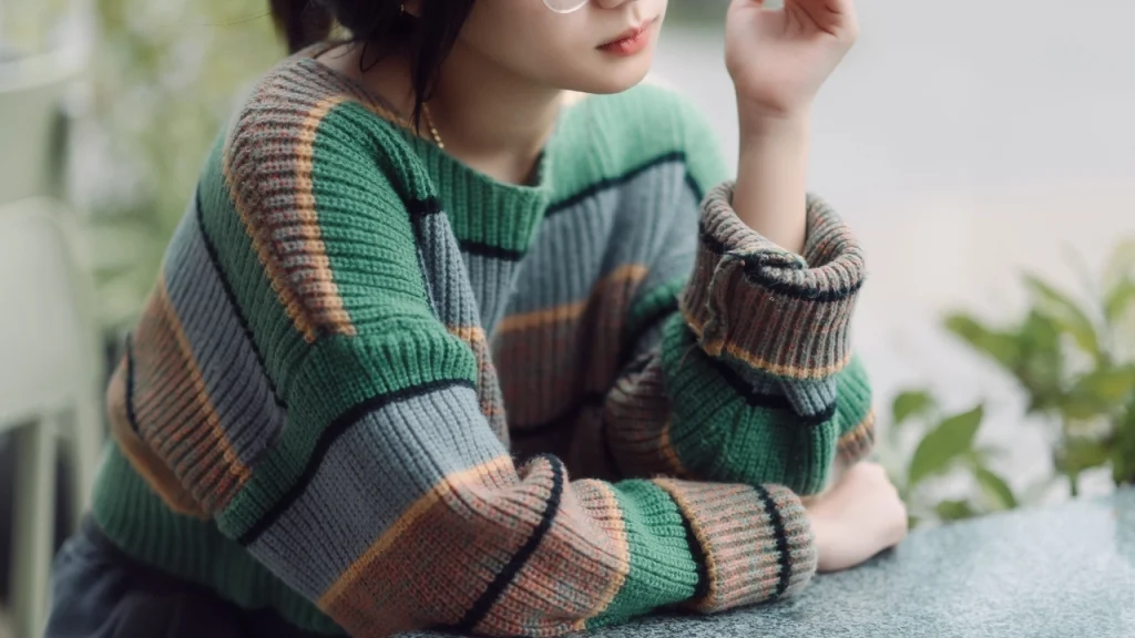 Woman wearing a custom striped sweater developed through OEM knitwear production