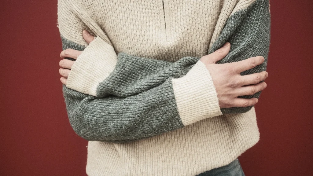 Close-up of a color-block knit sweater showing sleeve and body fit details