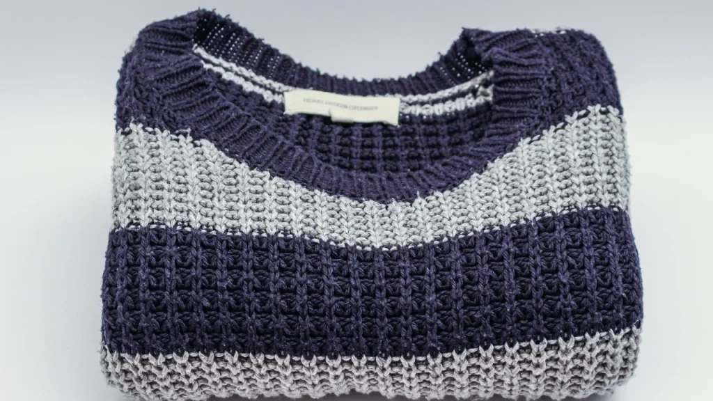 Folded striped sweater showing knit texture and private label knitwear presentation