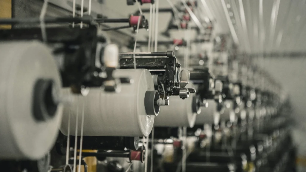 Close-up of yarn rolls on a sweater factory production line.
