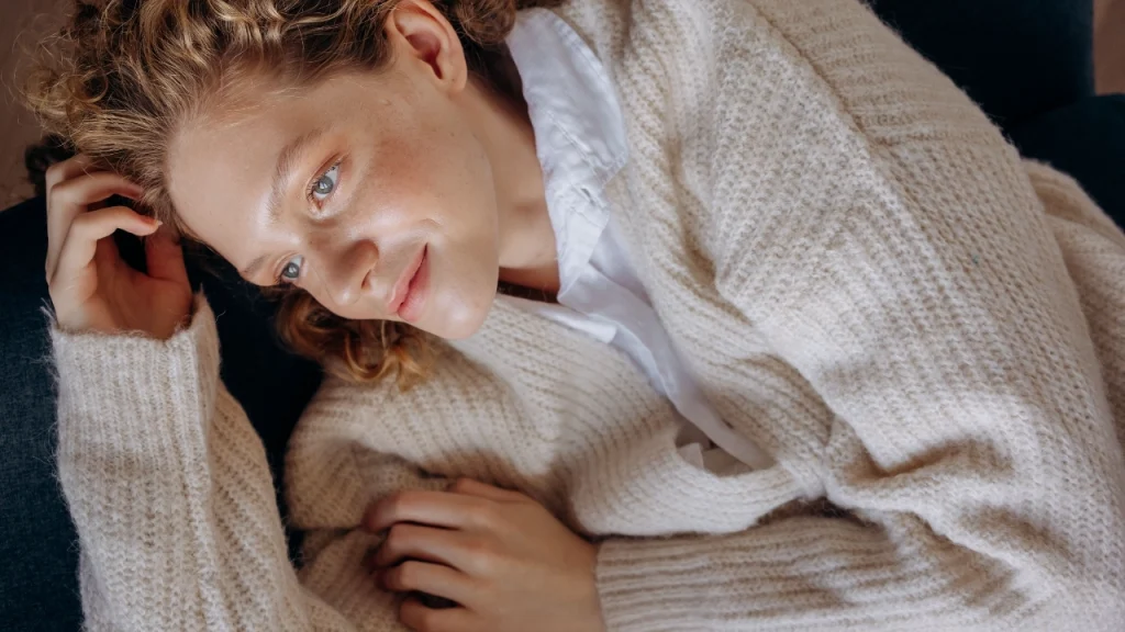 Wholesale knitwear cream cardigan styled in a relaxed lifestyle setting for casual sweater collection visuals.