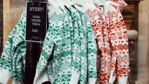Green and red Nordic jumpers displayed on a rack for a wholesale knitwear collection