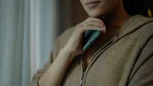 Zip cardigan close-up with soft neutral knit texture, front zipper, and relaxed loungewear styling.