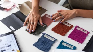 Hands reviewing fabric swatches for pre production sample color and material selection.