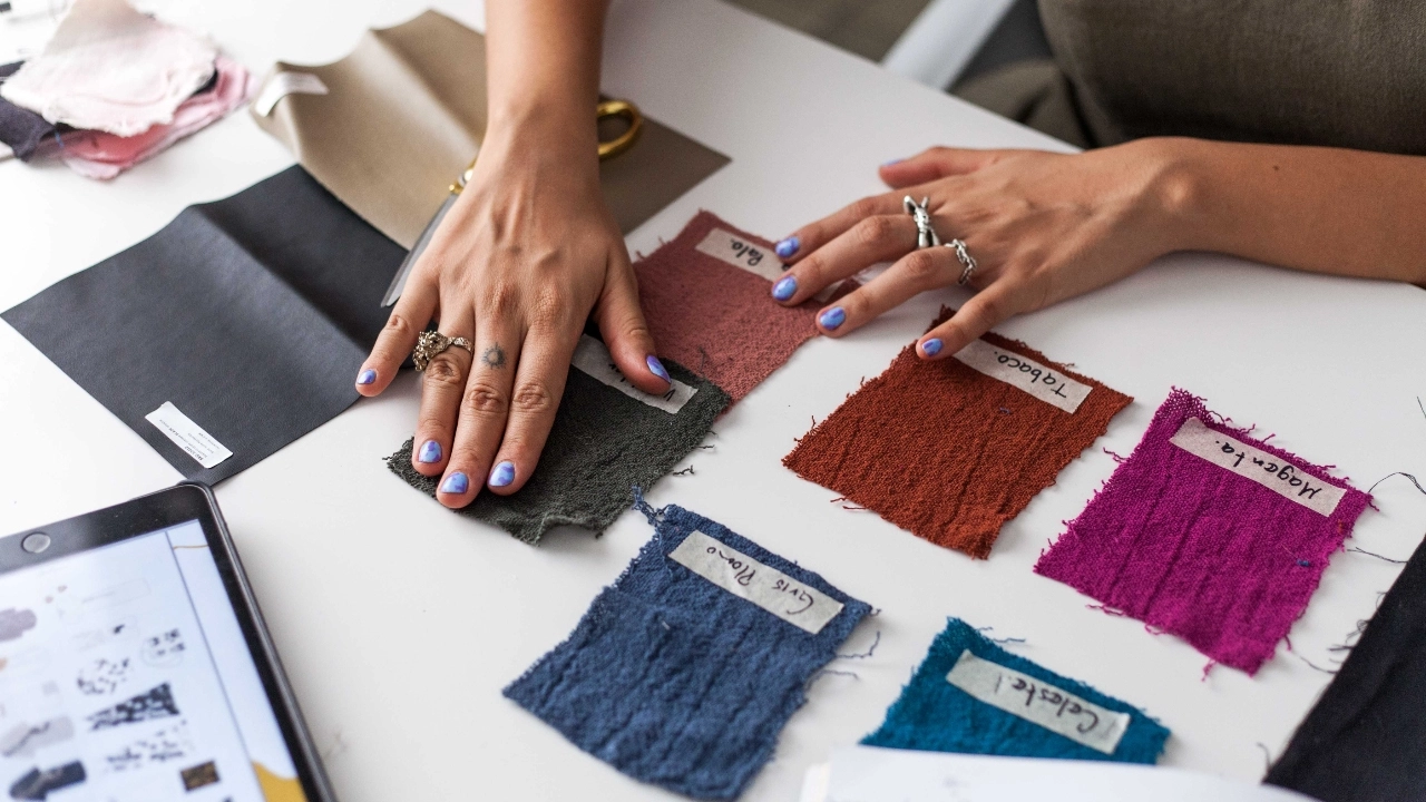 Hands reviewing fabric swatches for pre production sample color and material selection.