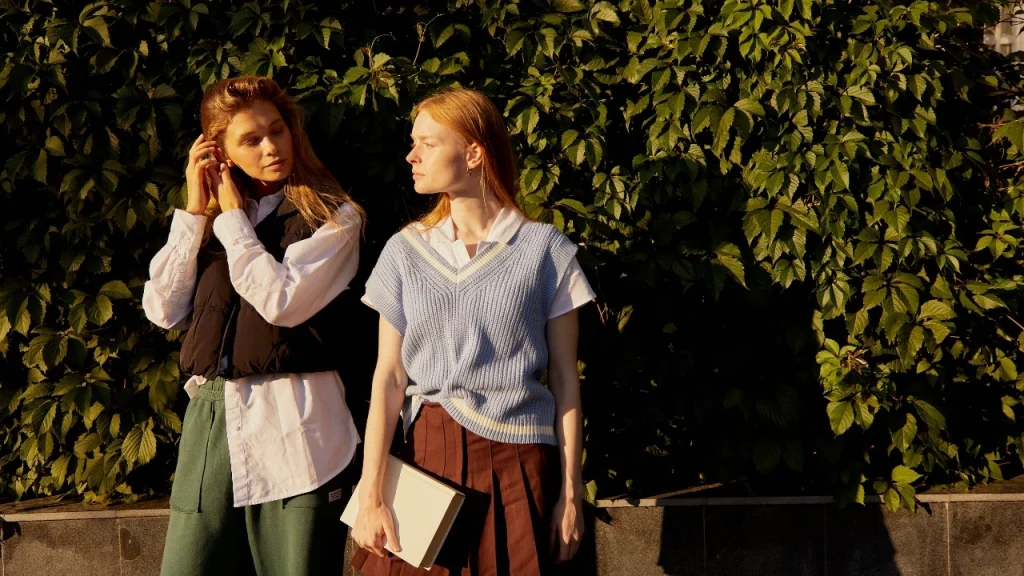 Women wearing knitted custom sweater vests with casual layered outfits.