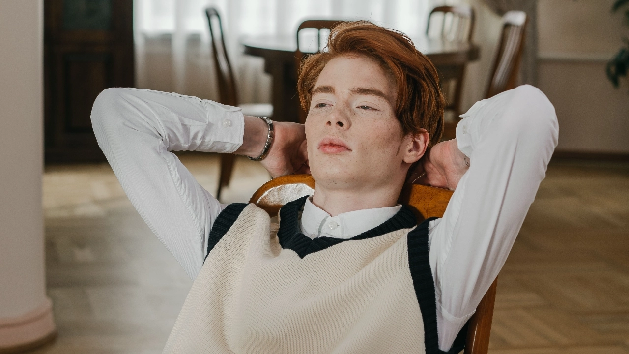 Man wearing a cream custom sweater vest over a white shirt.