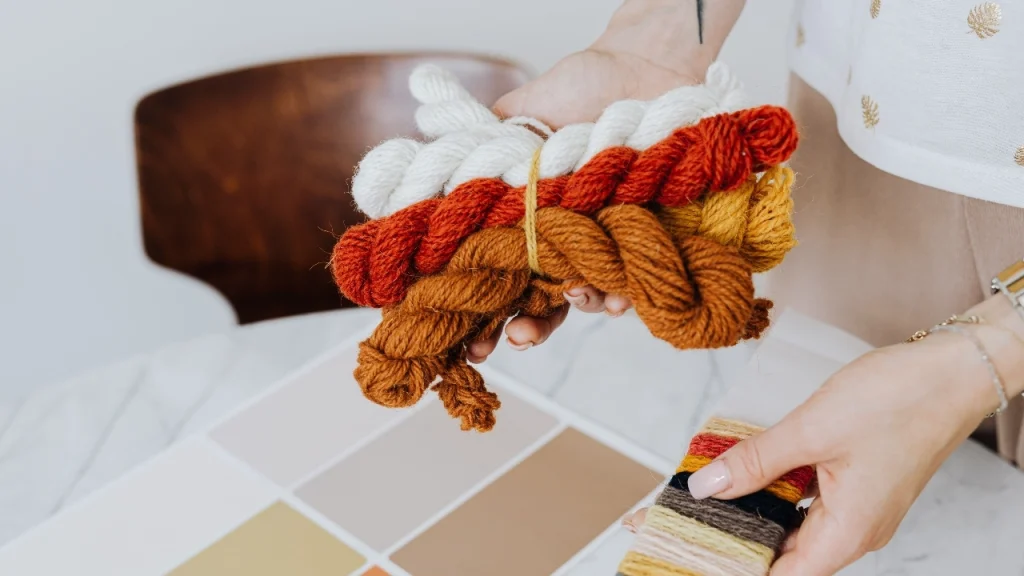 Designer holding yarn bundles for pre production sample color selection.