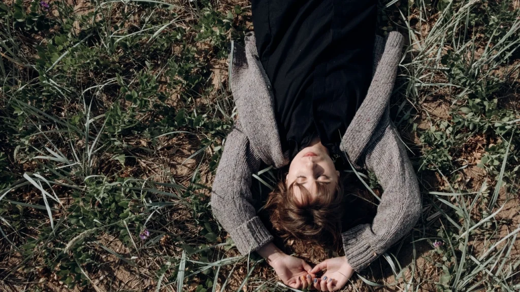 Woman relaxing outdoors while wearing a gray Cashmere Cardigan.