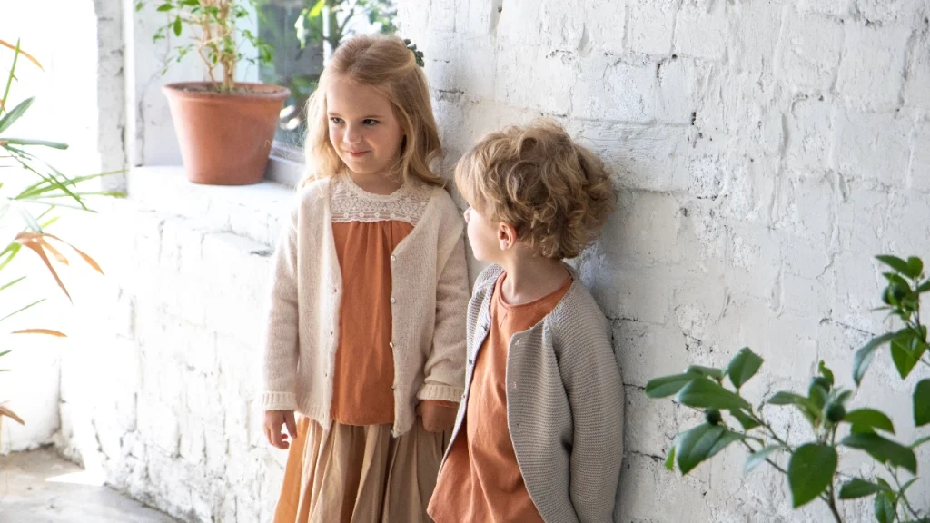 Children wearing neutral-colored Cashmere Cardigan styles indoors.