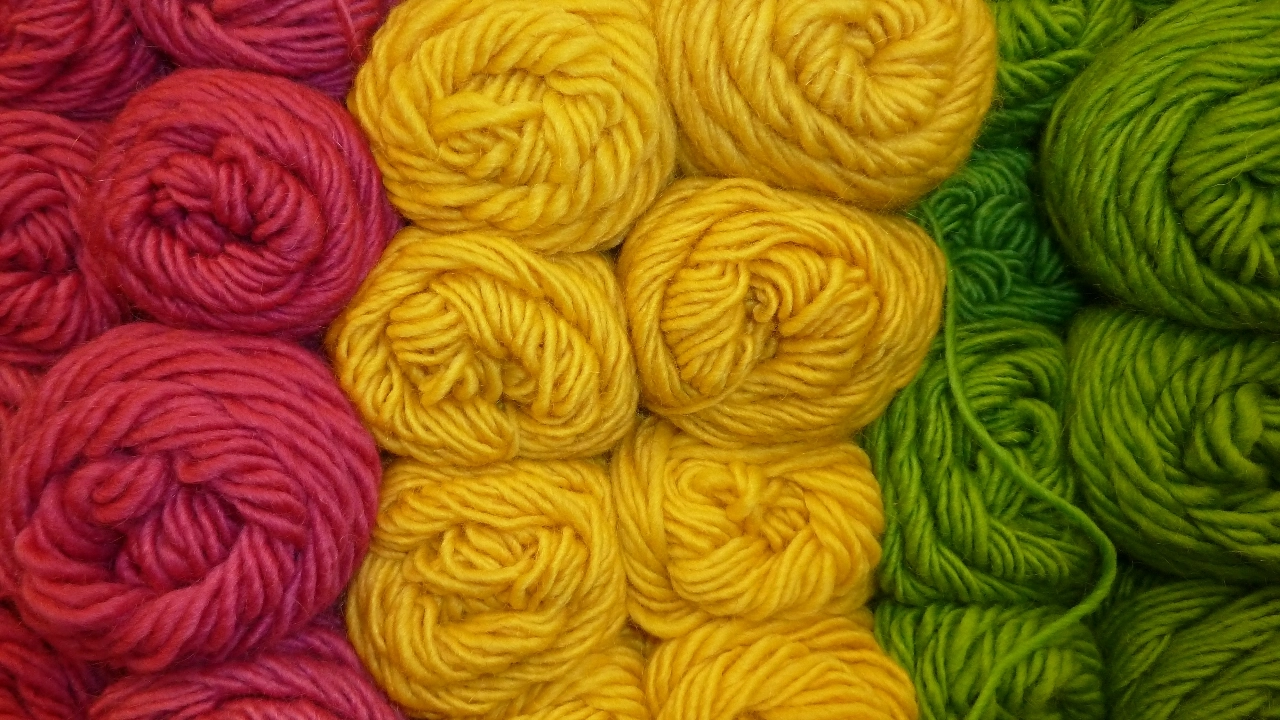 Bright pink, yellow, and green yarn balls arranged by Dye Lot color groups.