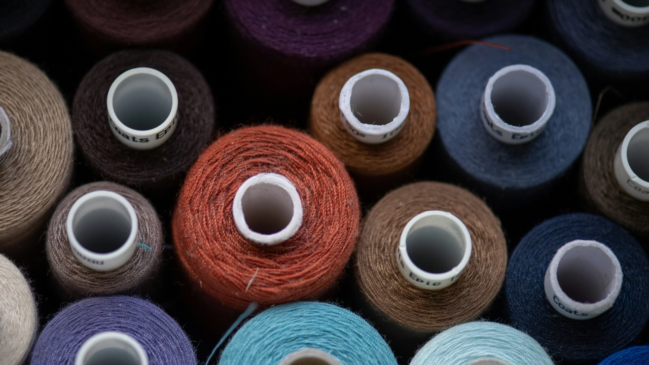 Colorful yarn and thread spools arranged for small batch apparel production by low MOQ clothing manufacturers.