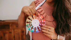 Close-up of a designer selecting colors from a color wheel for sweater measurement chart development.