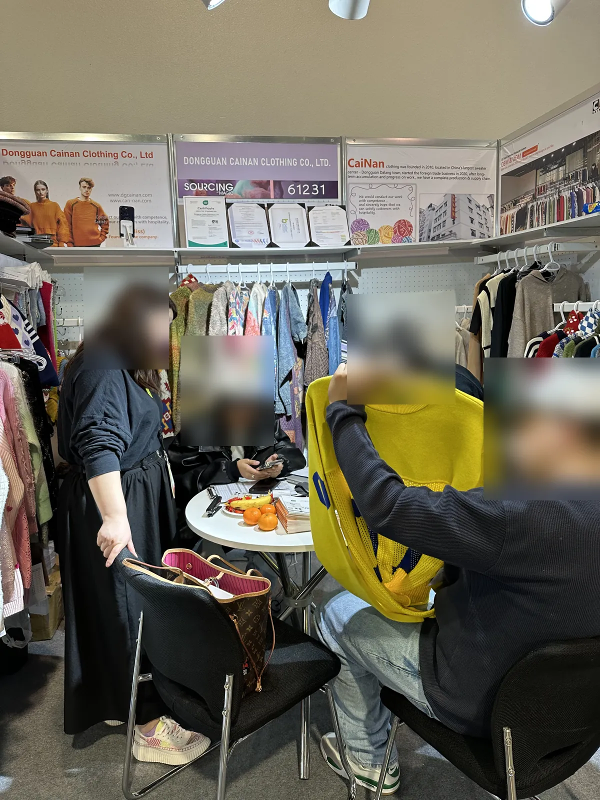 Buyer inspecting a knit sweater at the Cainan booth