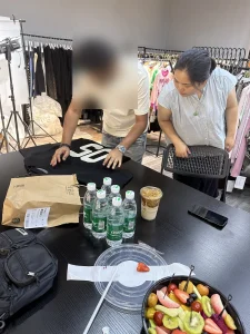 Buyer reviewing knit samples with a Cainan merchandiser