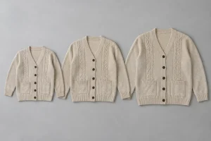 Three sizes of an oatmeal button-front cable cardigan laid flat in one aligned set.