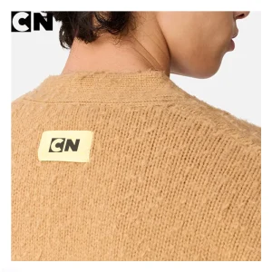 Woven CN brand label on a textured knit cardigan