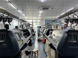 Computerized flat knitting machines in the Cainan knitting workshop