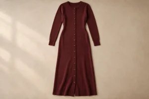 Burgundy long-sleeved knitted dress laid flat with a full-length button placket