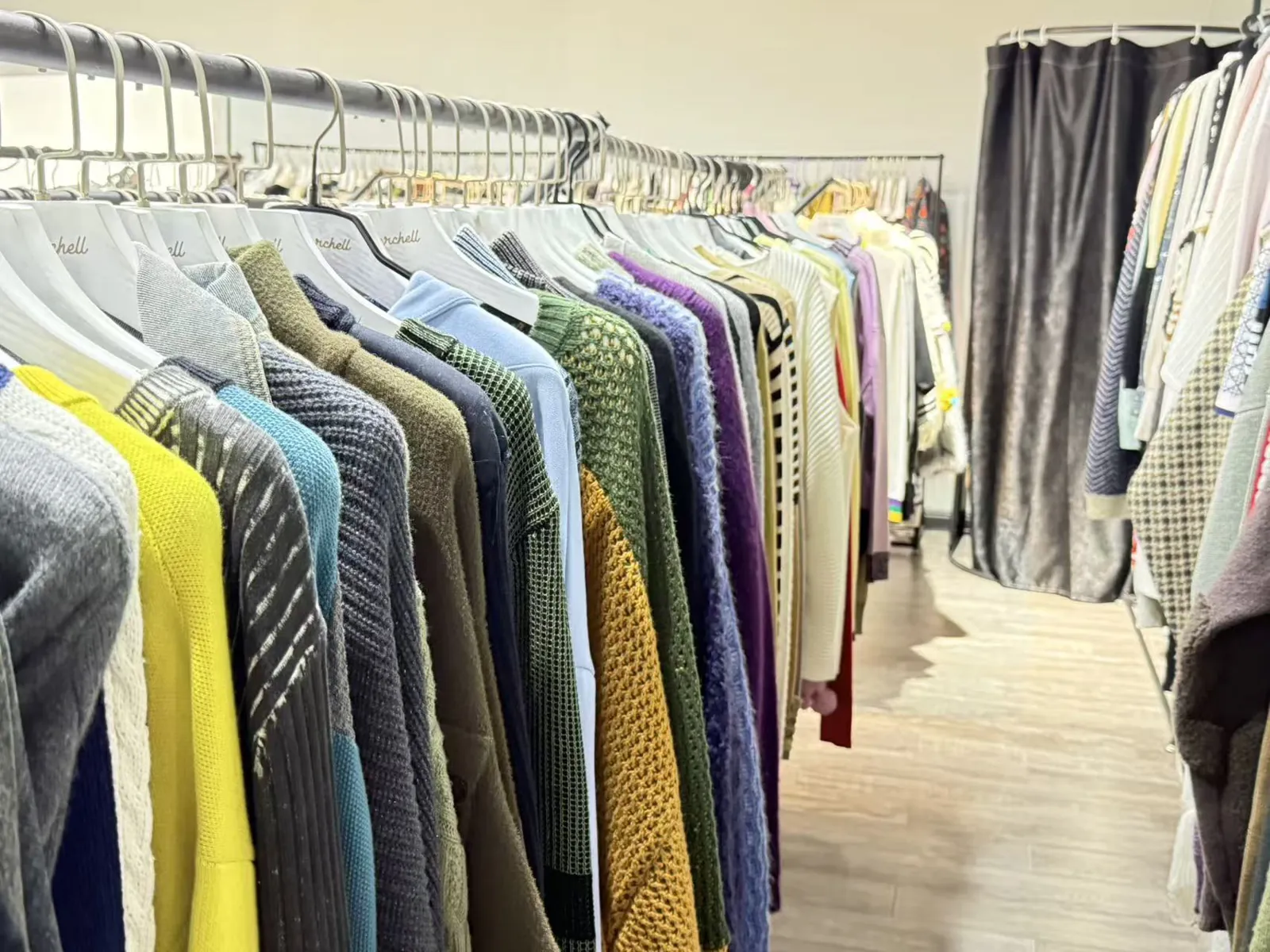 Sample room with knit sweaters and cardigans on racks