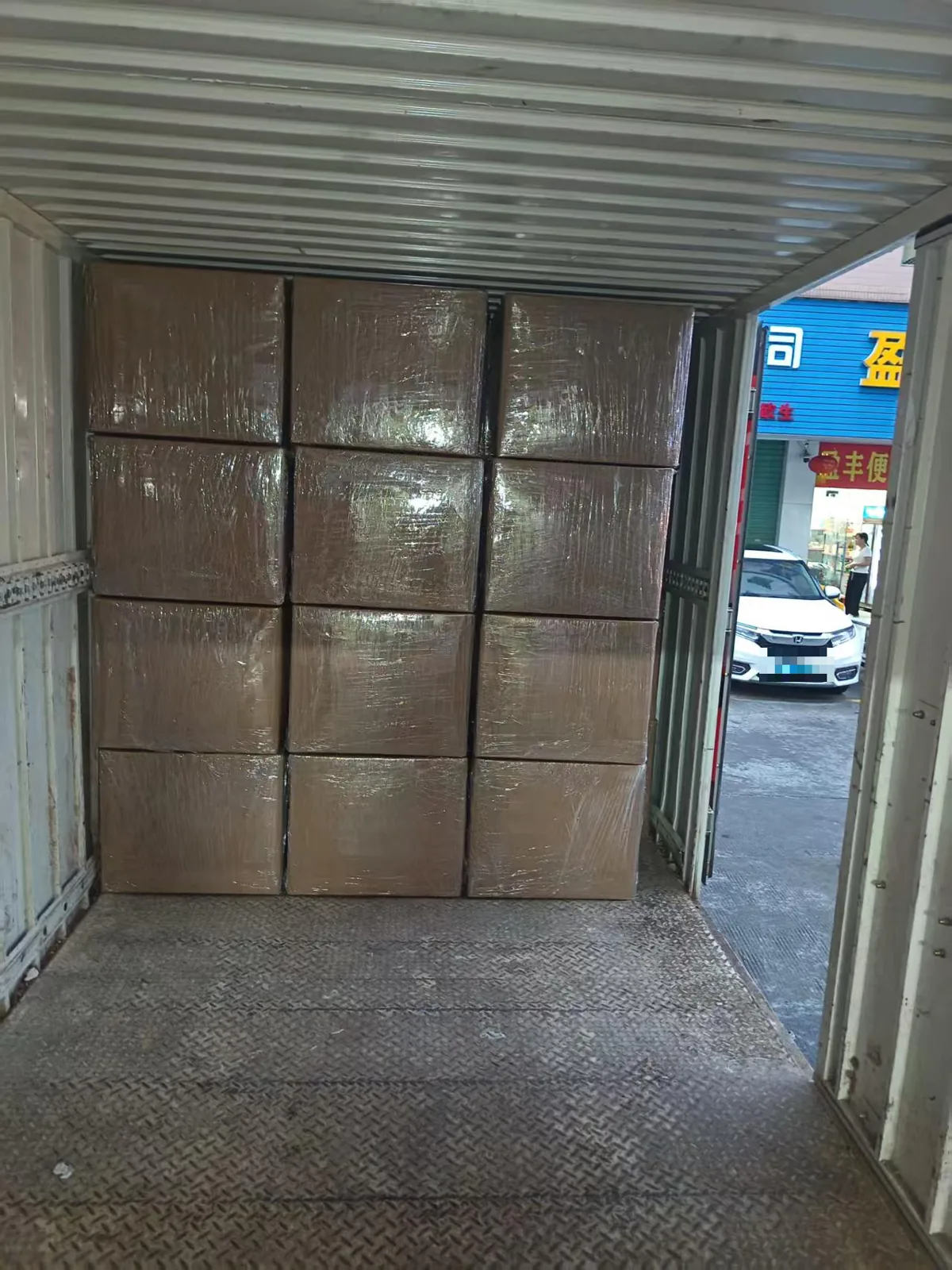 Stretch-wrapped sweater cartons stacked tightly inside a truck container