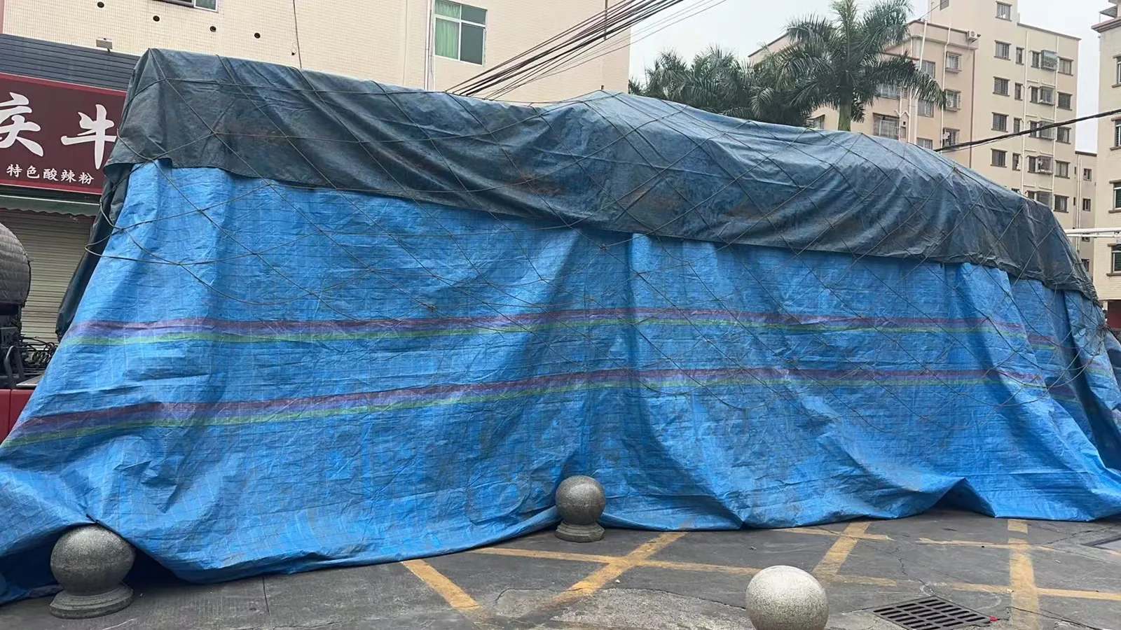Knitwear shipment covered with waterproof tarpaulin and secured for road transport