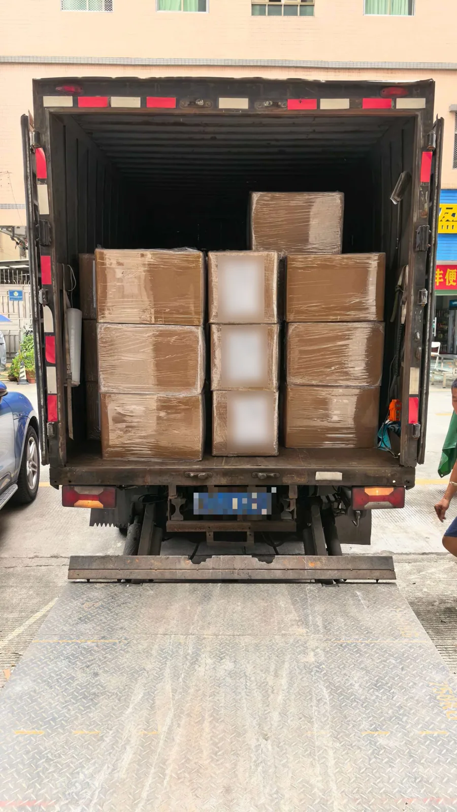 Stretch-wrapped knitwear cartons loaded in a box truck at the factory